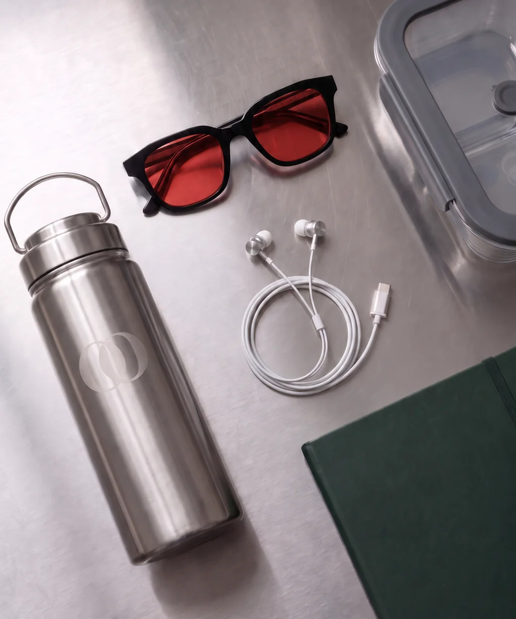 The bottle, the red lens, the earphones and the lunchbox on steel